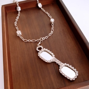 Detail of silver glasses pendant with clear cubic zirconia on a Figaro chain