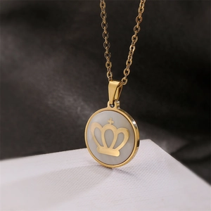 Vue macro du collier avec pendentif rond doré avec nacre blanche et emblème de couronne