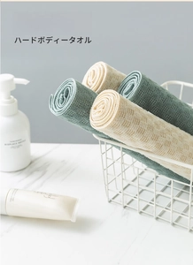 Close-up of textured waffle weave back scrubbers in sage green and beige colors