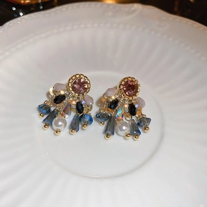 Detail of vintage palace style earrings with pink crystal and white pearl tassels