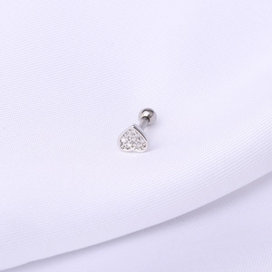 Macro detail of silver heart cartilage stud with pavé-set clear zircons and screw ball back