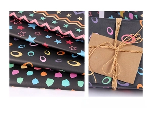 Detail of black striped gift wrapping paper with colorful geometric patterns and ribbon