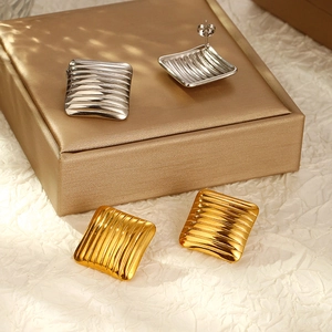 Orecchini quadrati chic placcati oro 18K e argento con superficie ondulata su portagioie