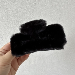 Detail of soft black faux fur rectangular claw clip for elegant women hair styling