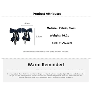 Detailed specs of dark blue fabric bow earrings with black glass tassel and silver pins