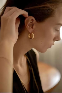 Polished 18k gold plated chunky hoop earring shown on ear for style and scale