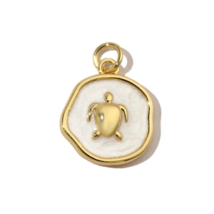 Macro detail of a gold-plated turtle pendant with white enamel and glitter finish