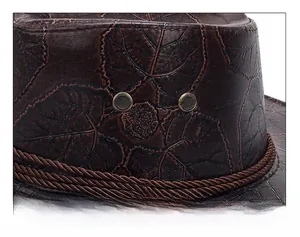 Macro detail of dark brown leather western hat with embossed leaf patterns and mesh vents
