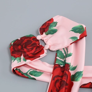 Detail of pink floral fabric showing red rose print and matching covered buttons