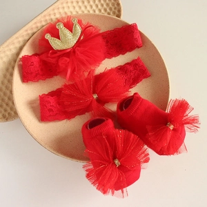 Detailed close-up of red lace baby headbands with crown and bow in a gift tray