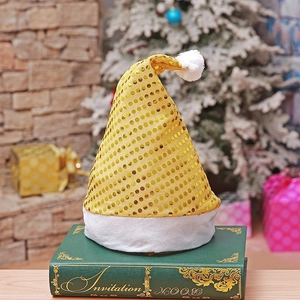 Golden sequin Christmas hat with white plush trim shown against a festive holiday background