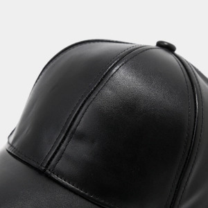 Macro detail of high-quality black PU leather baseball cap showing fine texture and stitching