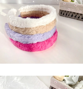 Close-up of four plush faux rabbit fur headbands in candy colors stacked on a white surface