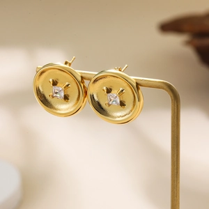 Macro shot of 18K gold button earrings featuring a sparkling square zircon stone