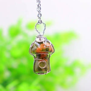 Macro shot of handmade silver wire wrapped green stone mushroom pendant necklace