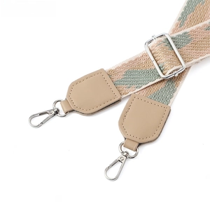Dettaglio tracolla geometrica regolabile con pelle kaki e ganci argentati per borsa a tracolla