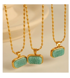 Detailed view of three gold-plated rice chain necklaces with green amazonite pendants