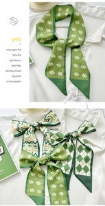 Detail showing green silk scarf with geometric patterns tied on a white shirt