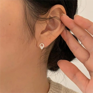 Close-up of a minimalist 925 sterling silver hoop earring with a sparkling zircon on model