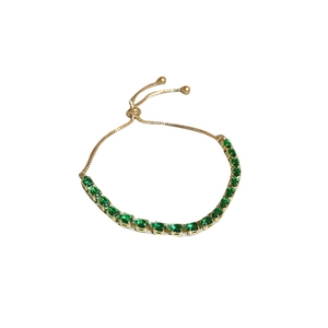 Adjustable gold bracelet with green teardrop zircon stone and tassel on white background