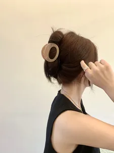 Chic acetate hair claw clip in creamy marble brown securing a stylish updo hairstyle
