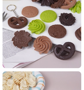 Detailed view of realistic artificial pretzel and cookie keychain charms in various colors