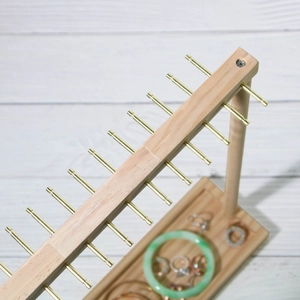 Wooden jewelry display stand with gold metal hooks for necklaces and bracelets