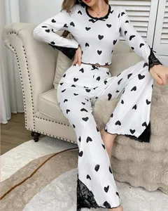 Detail of white rib-knit pajama set with black heart prints and delicate lace trim edges
