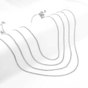 Detailansicht der 2,3mm silbernen Edelstahl-Cuban-Gliederketten auf weißem Seidenhintergrund