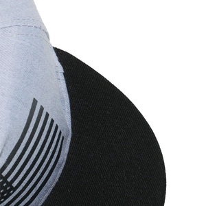Detail of greyish-blue fabric and black brim with stitched US flag pattern on the hip-hop cap