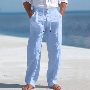 Detail of light blue linen pants featuring adjustable drawstring waist and button closure