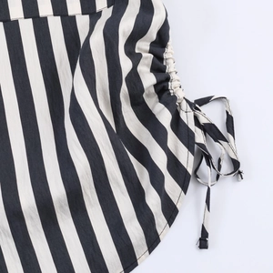 Detailed close-up of side drawstring and striped fabric on long sleeve shirt