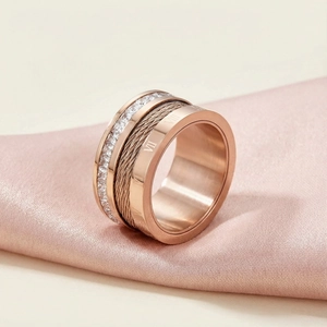 Detail of rose gold ring featuring steel cable texture, Roman numerals and pave crystals