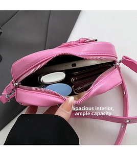 Vue intérieure du sac à rivets rose montrant sa grande capacité pour téléphone et portefeuille