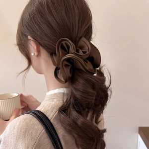 French vintage dark brown satin scrunchie shown on model in a soft minimalist setting