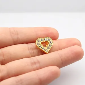 Close-up of heart-shaped gold pendant with sparkling rhinestones for DIY jewelry