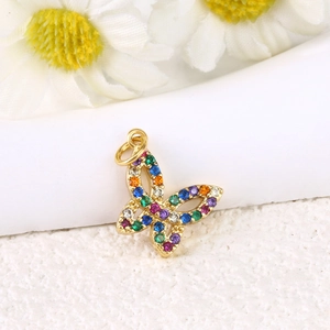 Close-up of golden butterfly pendant with colorful zircons next to daisies