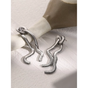 Detailed macro shot of wavy stainless steel chain drop earrings with silver finish texture