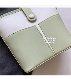 Dettaglio della borsa a secchiello bicolore bianco e verde con cuciture artigianali