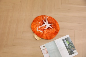 Detailed top view of a round salmon slice plush cushion on a light wooden floor