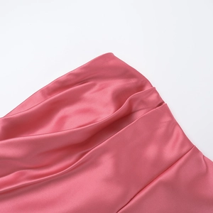 Detail shot of pink satin fabric featuring elegant ruched pleats and smooth silky texture
