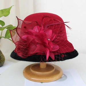 Detail of red wool felt hat with mesh veil, silk flower and black faux fur trim