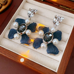 Detail of vintage flower earrings with blue petals and pearl in a wooden gift box