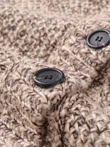 Close-up of thick knit beige mixed vest with detailed texture and black round buttons