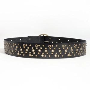 Macro detail of black leather belt with gold metal rivets and round ring decorations