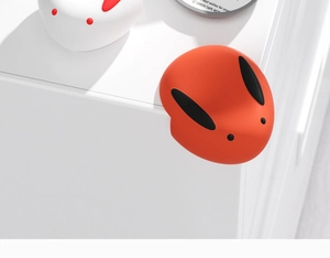 Dettaglio di un paraspigoli in silicone a forma di coniglio su un mobile bianco