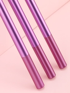 Détail de trois pinceaux de maquillage dégradé violet sur fond géométrique rose pastel