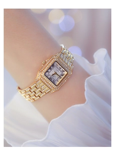 Close-up of luxury gold square watch for women with sparkling crystal dial and bezel