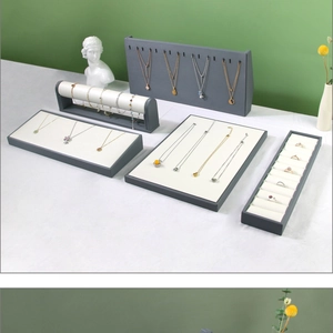Macro view of a gray jewelry display stand set with premium white leather cushions