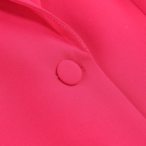 Macro detail of rose red suit collar and fabric covered button with fine textile texture